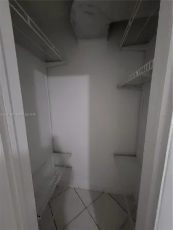 a large white kitchen with a stove a refrigerator a sink and dishwasher with a large window