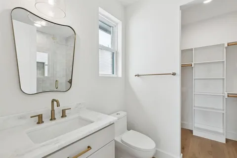 a bathroom with a toilet sink and mirror