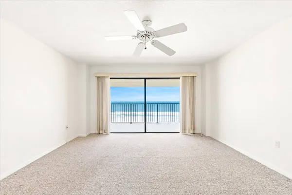 an empty room with a ceiling fan and a window