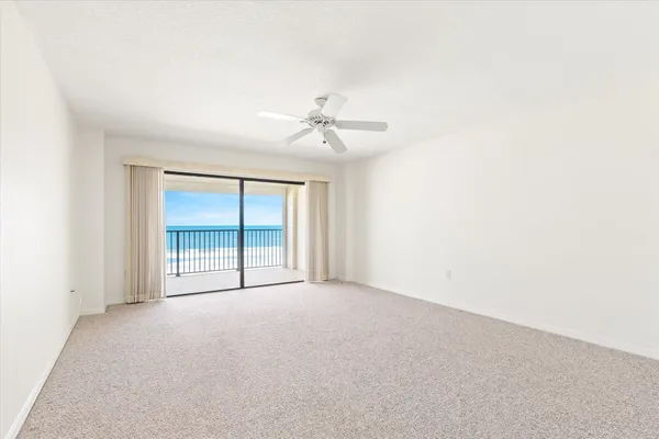 an empty room with a ceiling fan and a window