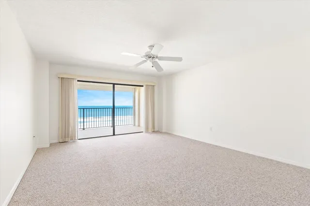 an empty room with a ceiling fan and a window