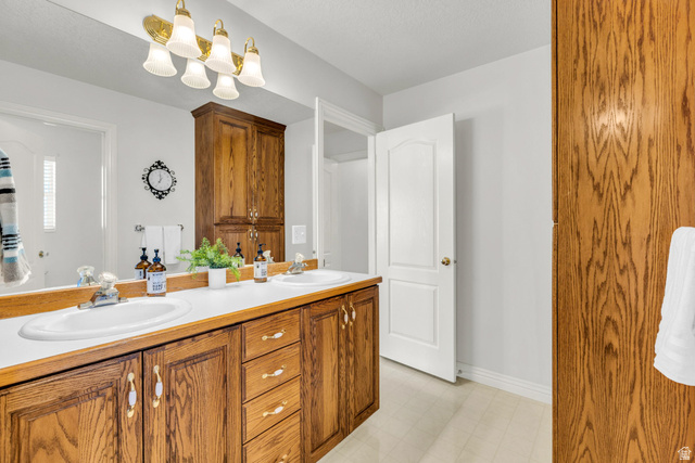 1060 West 2620th Street South Mapleton, UT 84664 - Photo 29 of 87 Bathroom with double vanity, light flooring, and a chandelier