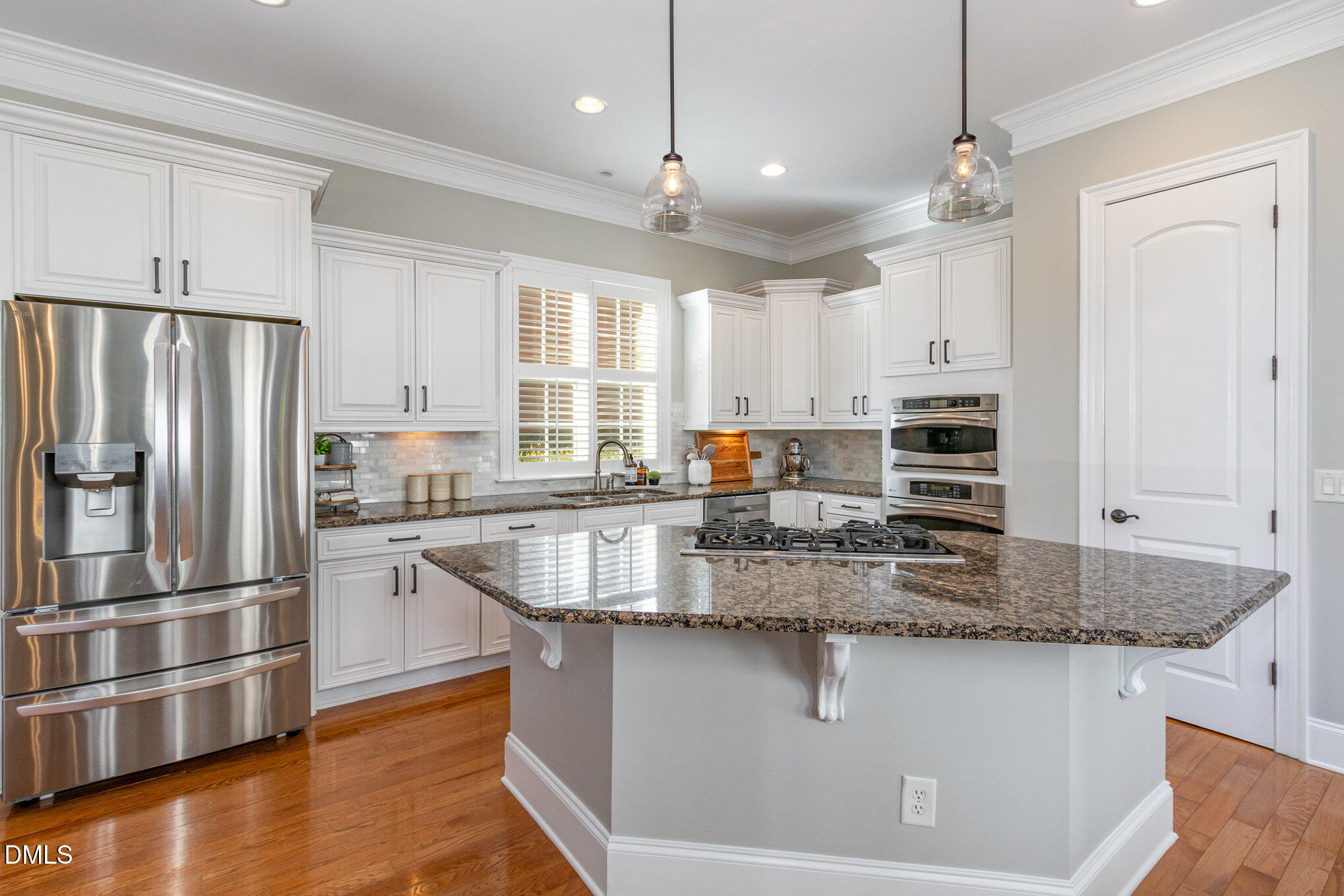 8517 Stonechase Drive Raleigh, NC 27613 - Photo 15 of 37 a kitchen with stainless steel appliances granite countertop a sink a stove a refrigerator a center island and cabinets