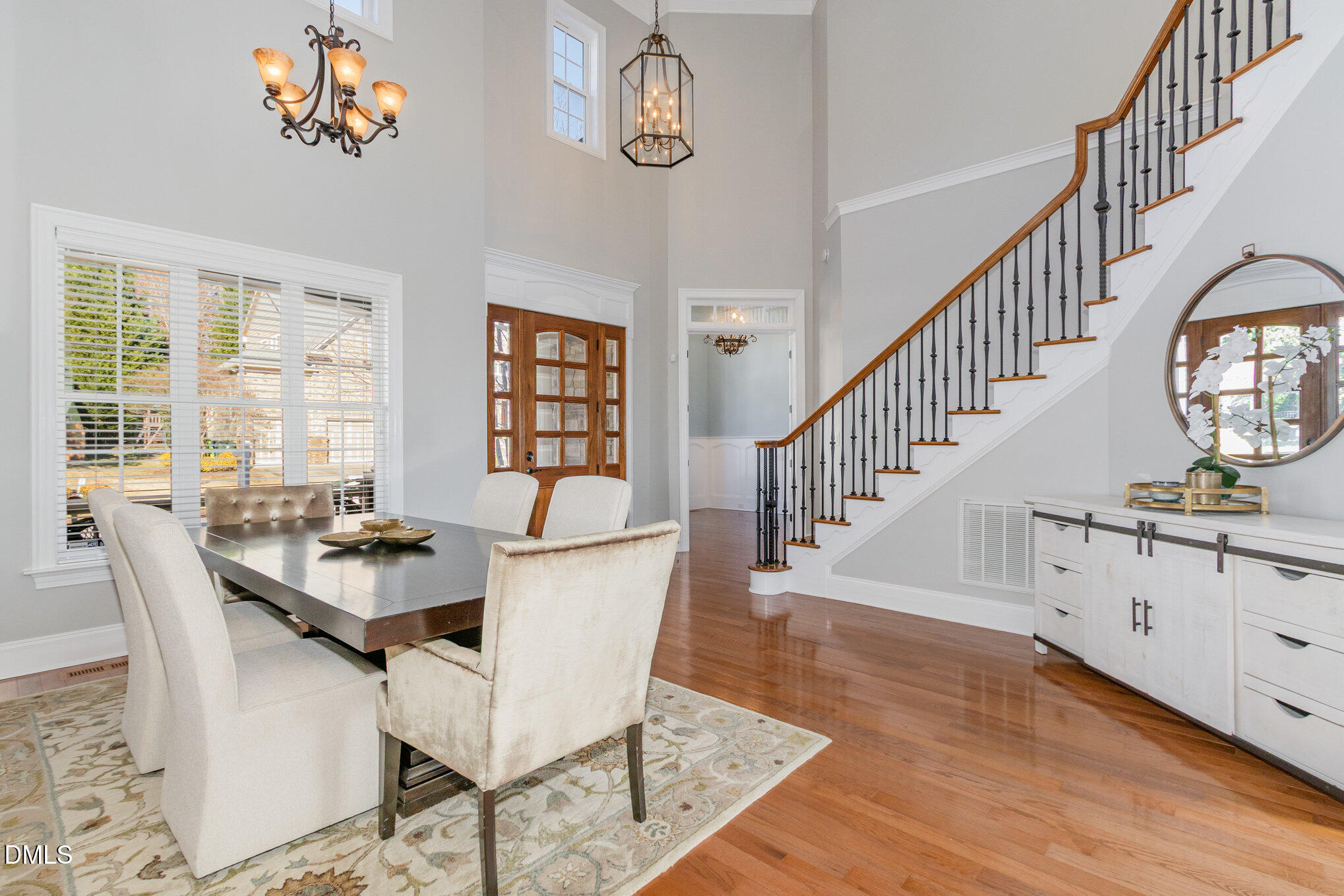 8517 Stonechase Drive Raleigh, NC 27613 - Photo 9 of 37 a dining room with wooden floor a chandelier a wooden table and chairs