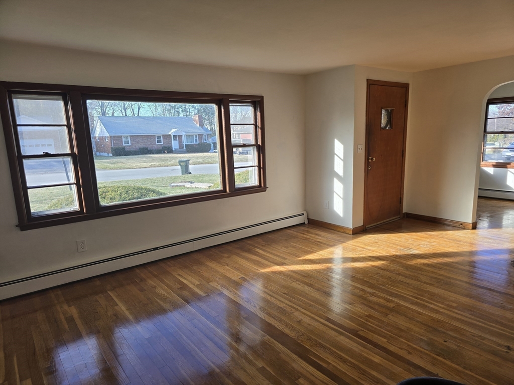 24 Pepka Drive Webster, MA 01570 - Photo 6 of 14 an empty room with wooden floor and windows