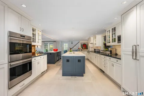 a large white kitchen with stainless steel appliances