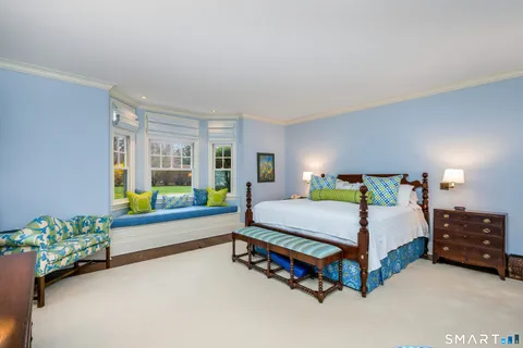 a bedroom with a bed mirror and window