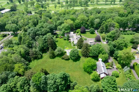 an aerial view of residential house with outdoor space and trees all around
