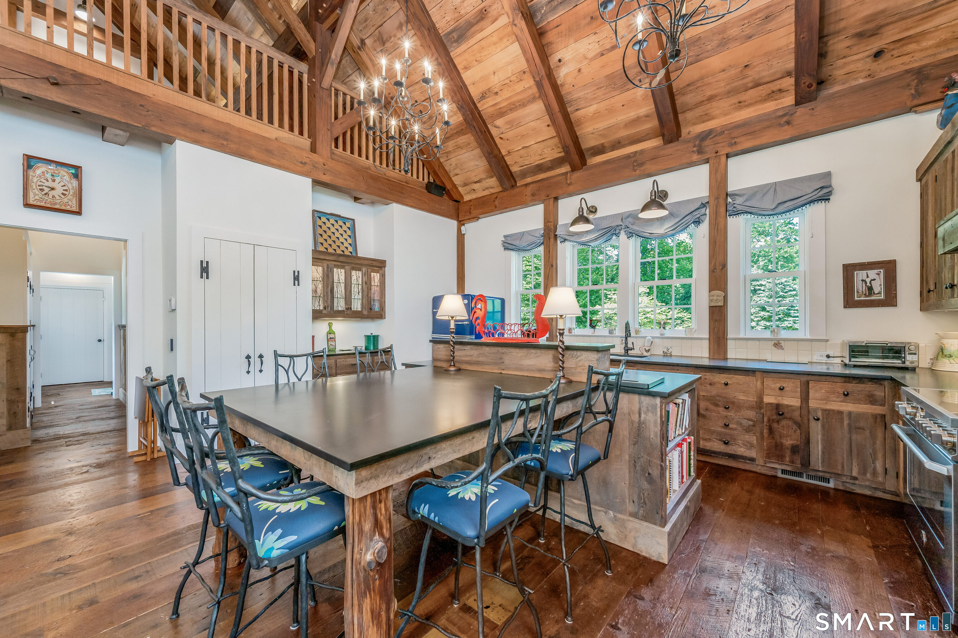 246 Brookside Road Darien, CT 06820 - Photo 37 of 40 a kitchen with stainless steel appliances granite countertop a table chairs stove and wooden floor