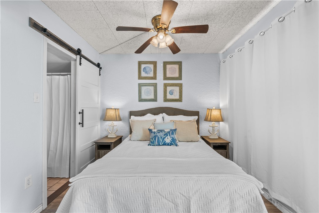 14401 Commodores Drive, Unit 101 Corpus Christi, TX 78418 - Photo 17 of 26 a bedroom with a bed and a chandelier