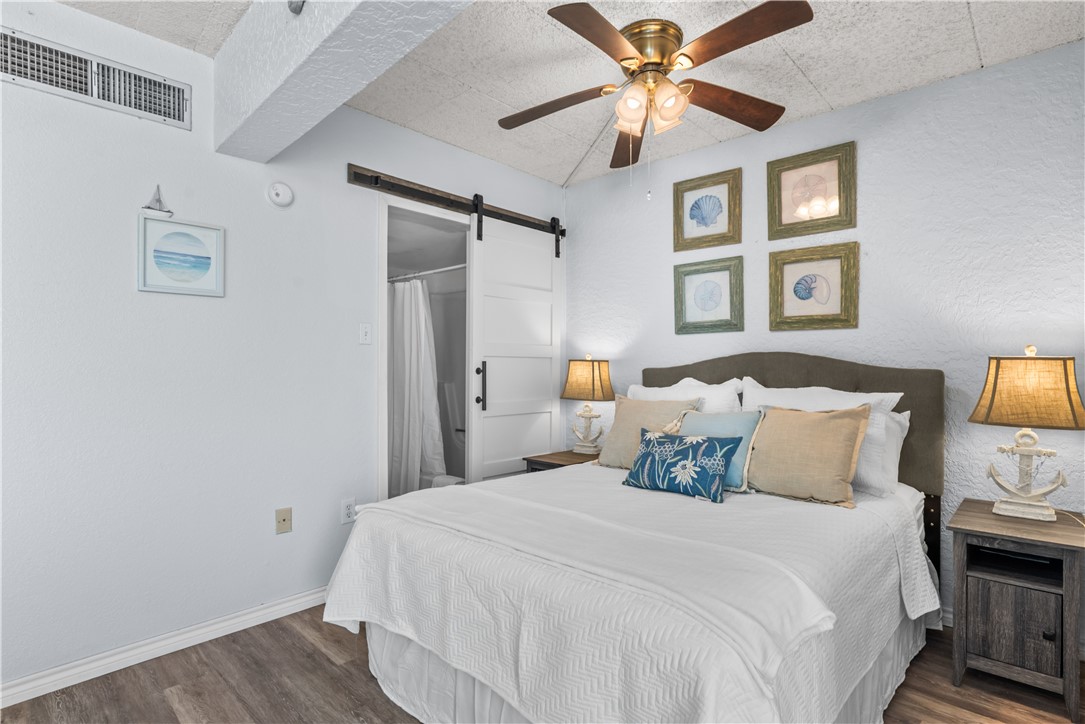 14401 Commodores Drive, Unit 101 Corpus Christi, TX 78418 - Photo 18 of 26 a bedroom with a bed and a ceiling fan