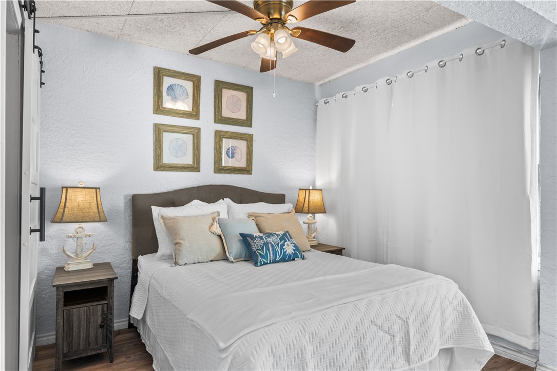 14401 Commodores Drive, Unit 101 Corpus Christi, TX 78418 - Photo 19 of 26 a bedroom with a bed and a chandelier