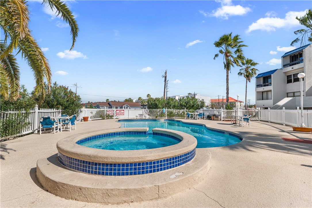 14401 Commodores Drive, Unit 101 Corpus Christi, TX 78418 - Photo 5 of 26 a view of a swimming pool with a table and chairs