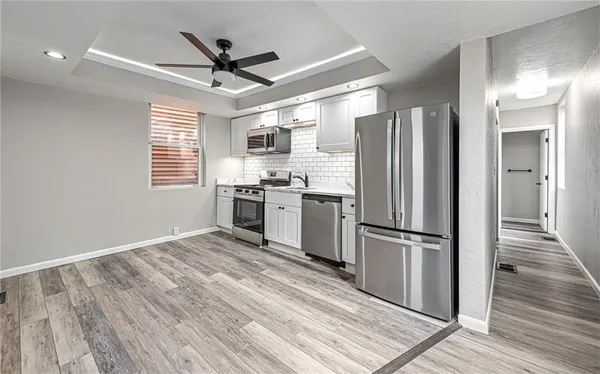 a kitchen with stainless steel appliances granite countertop a refrigerator a stove a sink and a wooden floors