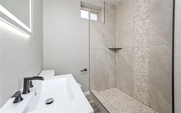 a bathroom with a sink a toilet and shower