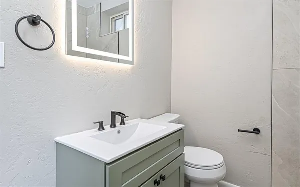 a bathroom with a toilet a sink and a mirror