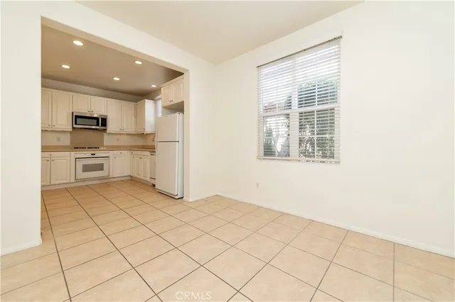 a kitchen with granite countertop white cabinets white stainless steel appliances and a sink
