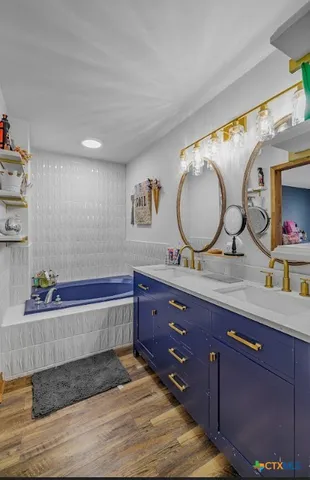 a spacious bathroom with double vanity and a mirror