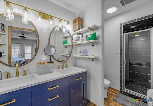 a bathroom with a granite countertop sink mirror vanity and toilet