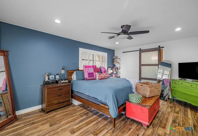 a bedroom with furniture and a flat screen tv