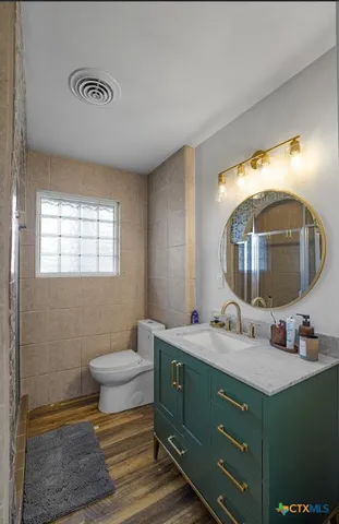 a bathroom with a toilet sink and mirror