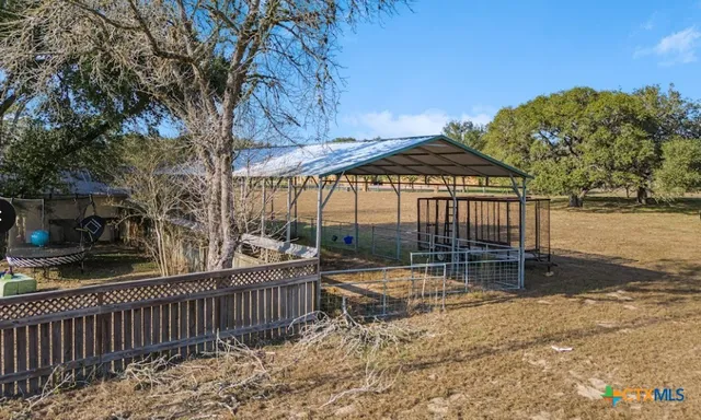 a patio area with wooden fence and a yard