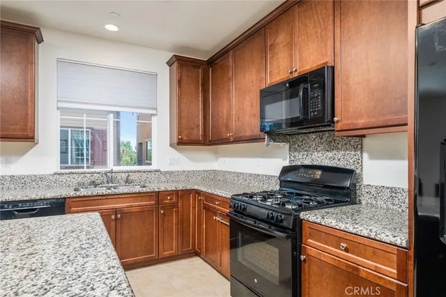 a kitchen with stainless steel appliances granite countertop a stove microwave and cabinets