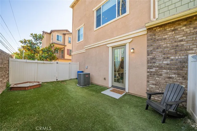 a view of a chair and table in backyard of the house