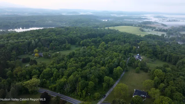 an aerial view of residential houses with outdoor space and trees