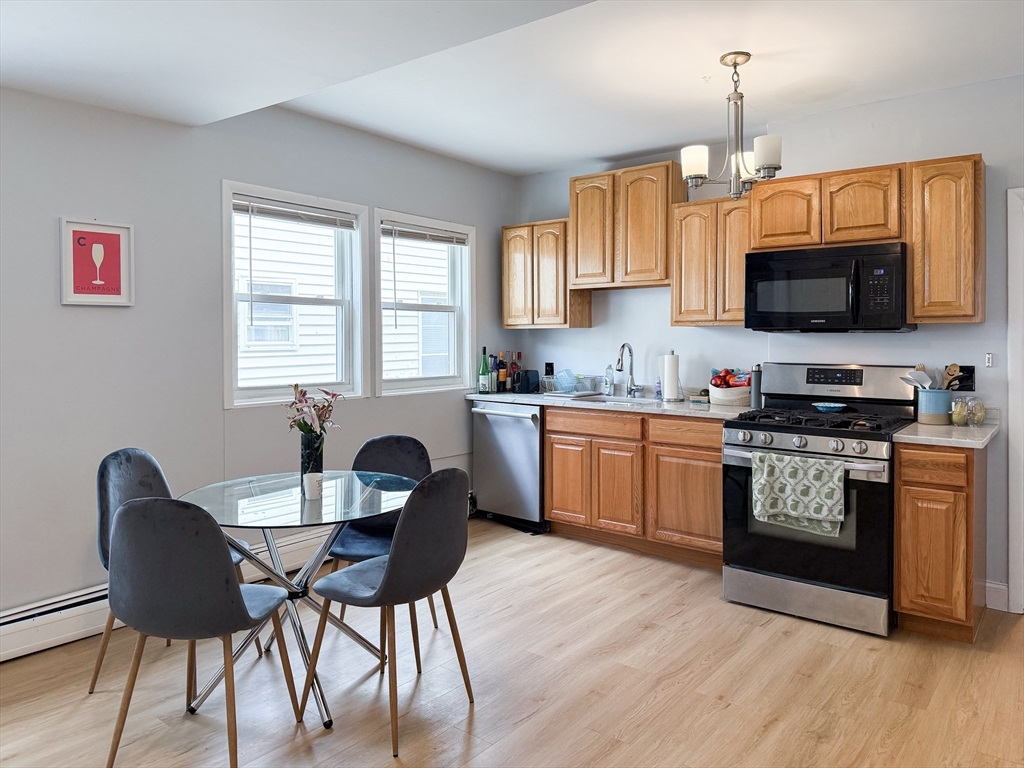 37 Harvard Avenue, Unit 37 Brookline, MA 02446 - Photo 1 of 1 a kitchen with a dining table and chairs