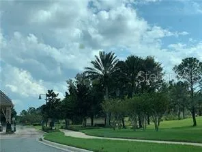 a view of a big house with a big yard and large trees