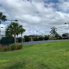 a view of a fountain in front of a big yard with plants