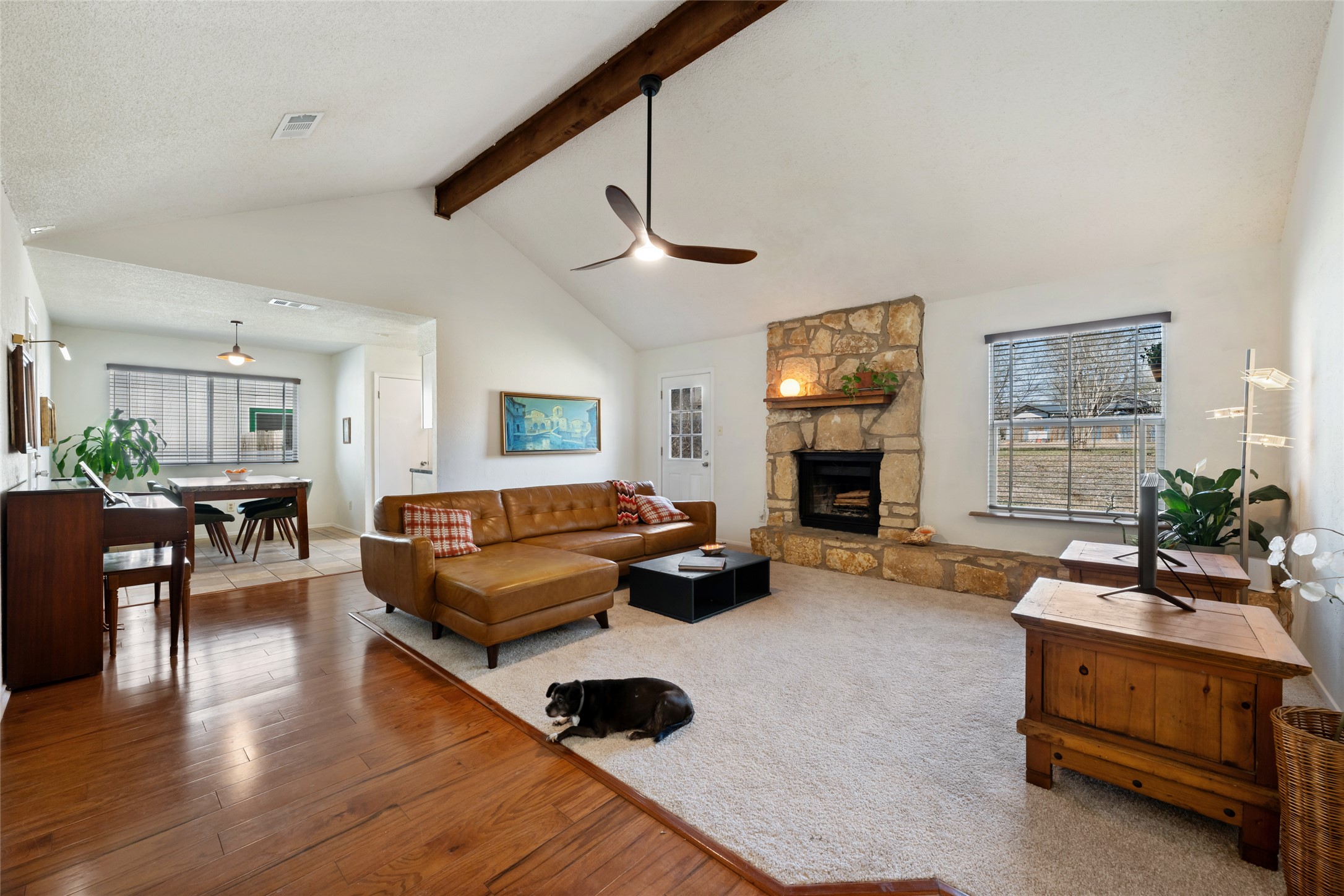 5100 Lambs Lane Austin, TX 78744 - Photo 1 of 31 Carpeted living area with plenty of natural light, a stone fireplace, ceiling fan, and hardwood / wood-style floors