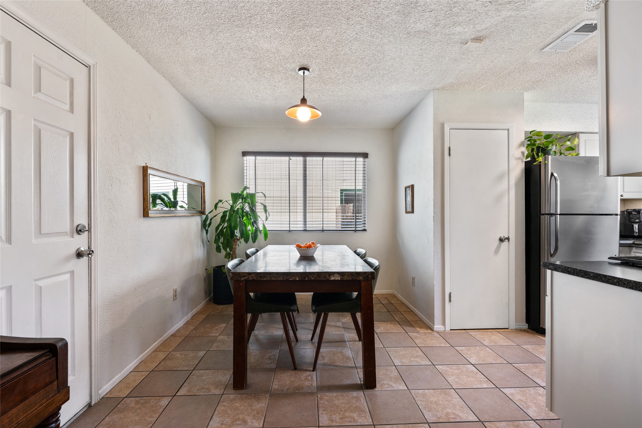5100 Lambs Lane Austin, TX 78744 - Photo 13 of 31 Dining space just off the kitchen, featuring a pendant light and tile flooring.