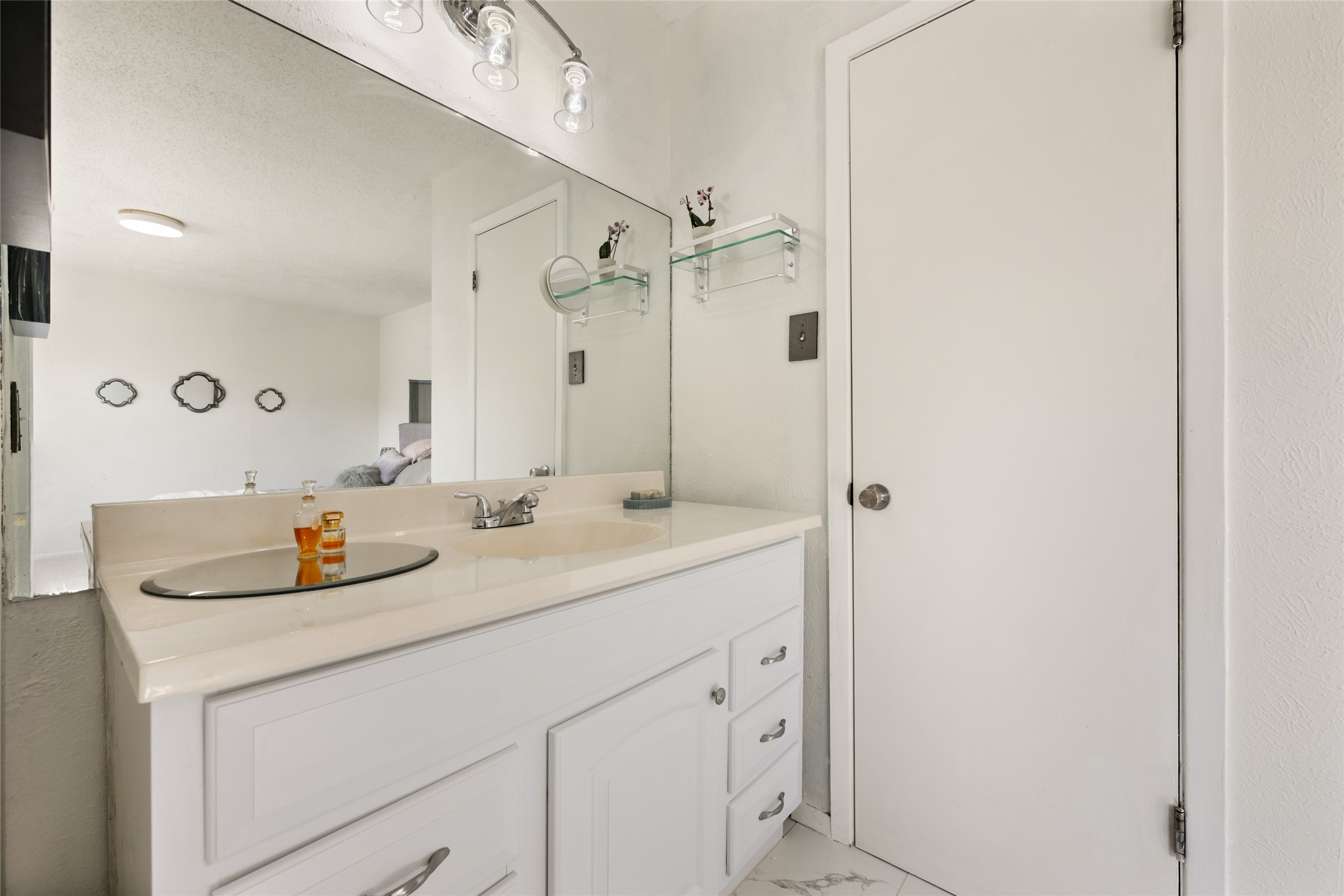 5100 Lambs Lane Austin, TX 78744 - Photo 27 of 31 Full bathroom off the primary bedroom with a sink and newly-installed tile floors.
