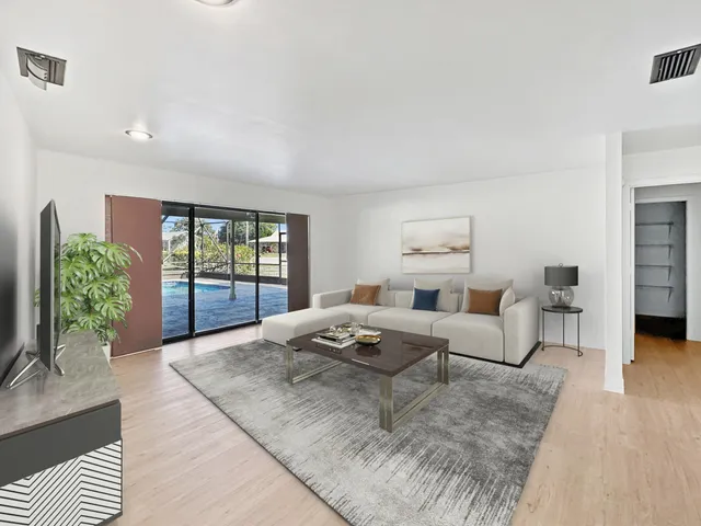 an empty room with wooden floor ceiling fan and windows