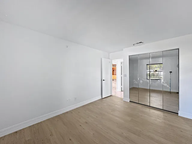 an empty room with fan and windows