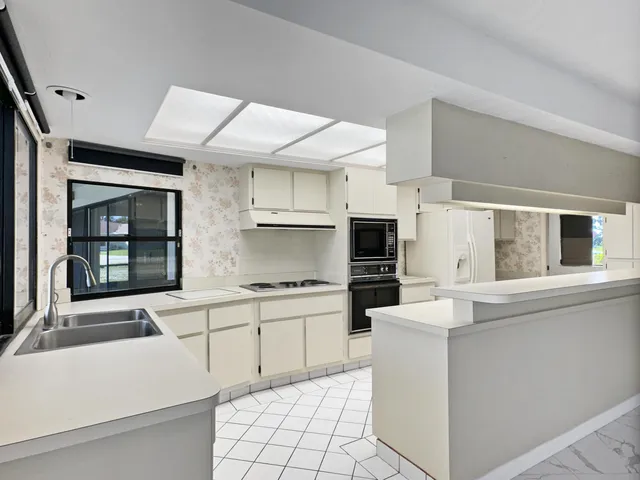 a kitchen with white cabinets and sink