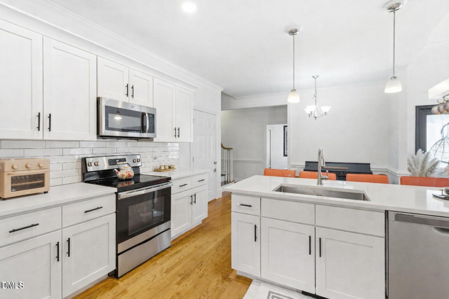 7605 Double E Court Raleigh, NC 27613 - Photo 15 of 49 a kitchen with white cabinets sink and stainless steel appliances