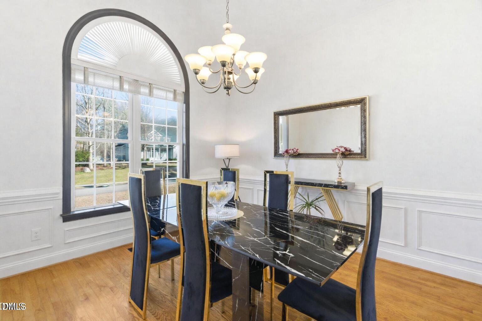 7605 Double E Court Raleigh, NC 27613 - Photo 20 of 49 a view of a dining room with furniture a chandelier and wooden floor
