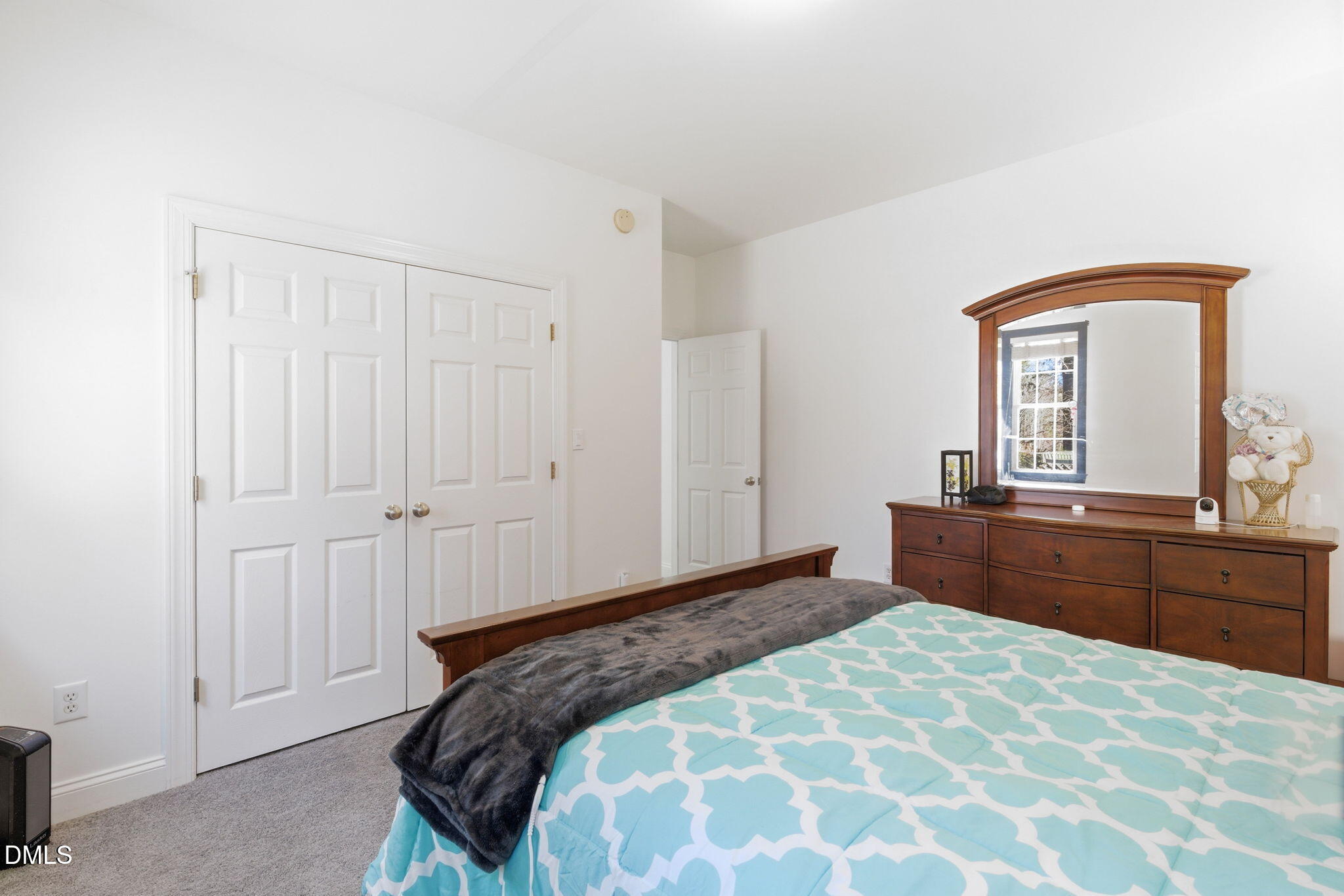 7605 Double E Court Raleigh, NC 27613 - Photo 28 of 49 a bedroom with a bed and a mirror on dresser
