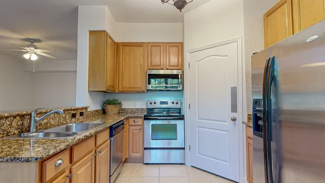 a kitchen with stainless steel appliances granite countertop a sink stove and refrigerator