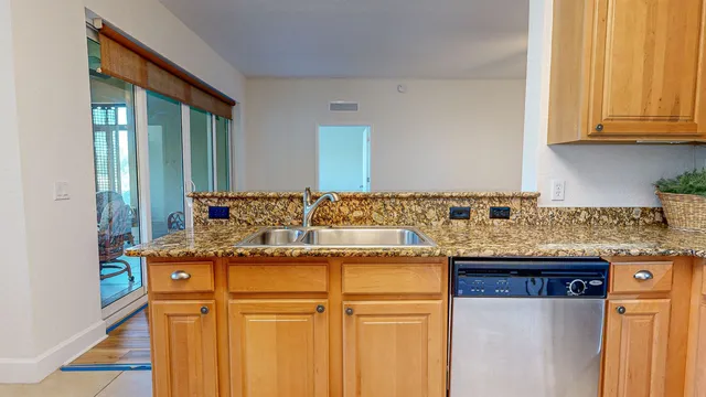 a kitchen with granite countertop a sink and cabinets