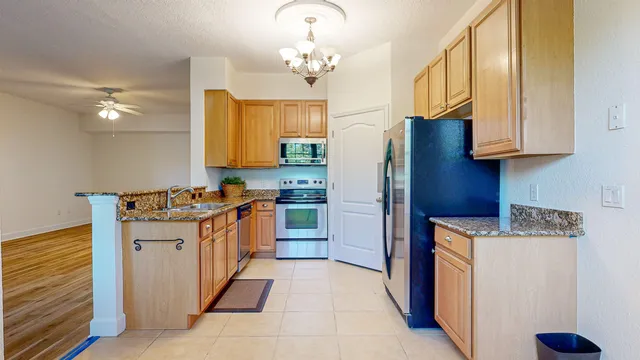 a kitchen with stainless steel appliances granite countertop a stove a refrigerator and a sink