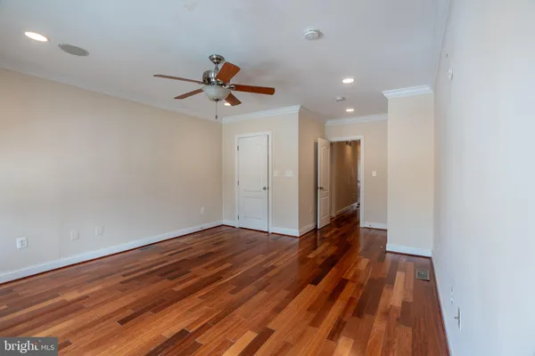 a view of room with wooden floor and ceiling fan