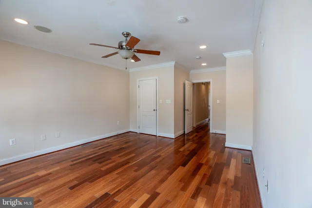 a view of room with wooden floor and ceiling fan