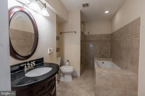 a bathroom with a sink a toilet and a mirror