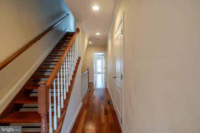 a view of a hallway with wooden floor and staircase