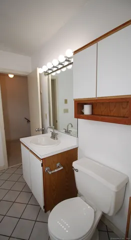 a bathroom with a granite countertop toilet sink and mirror