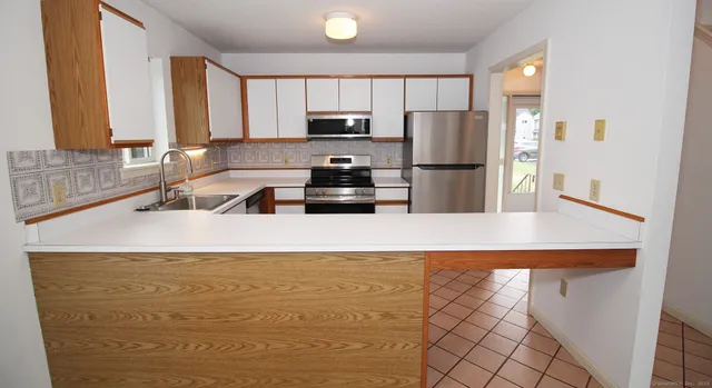 a kitchen with kitchen island a sink a stove and refrigerator